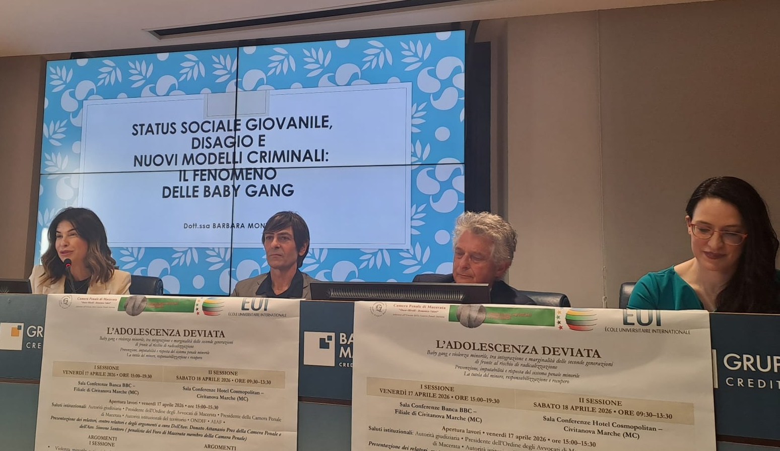 Quattro relatori al tavolo, sotto la proiezione Status sociale giovanile, disagio e nuovi modelli criminali: il fenomeno delle baby gang.