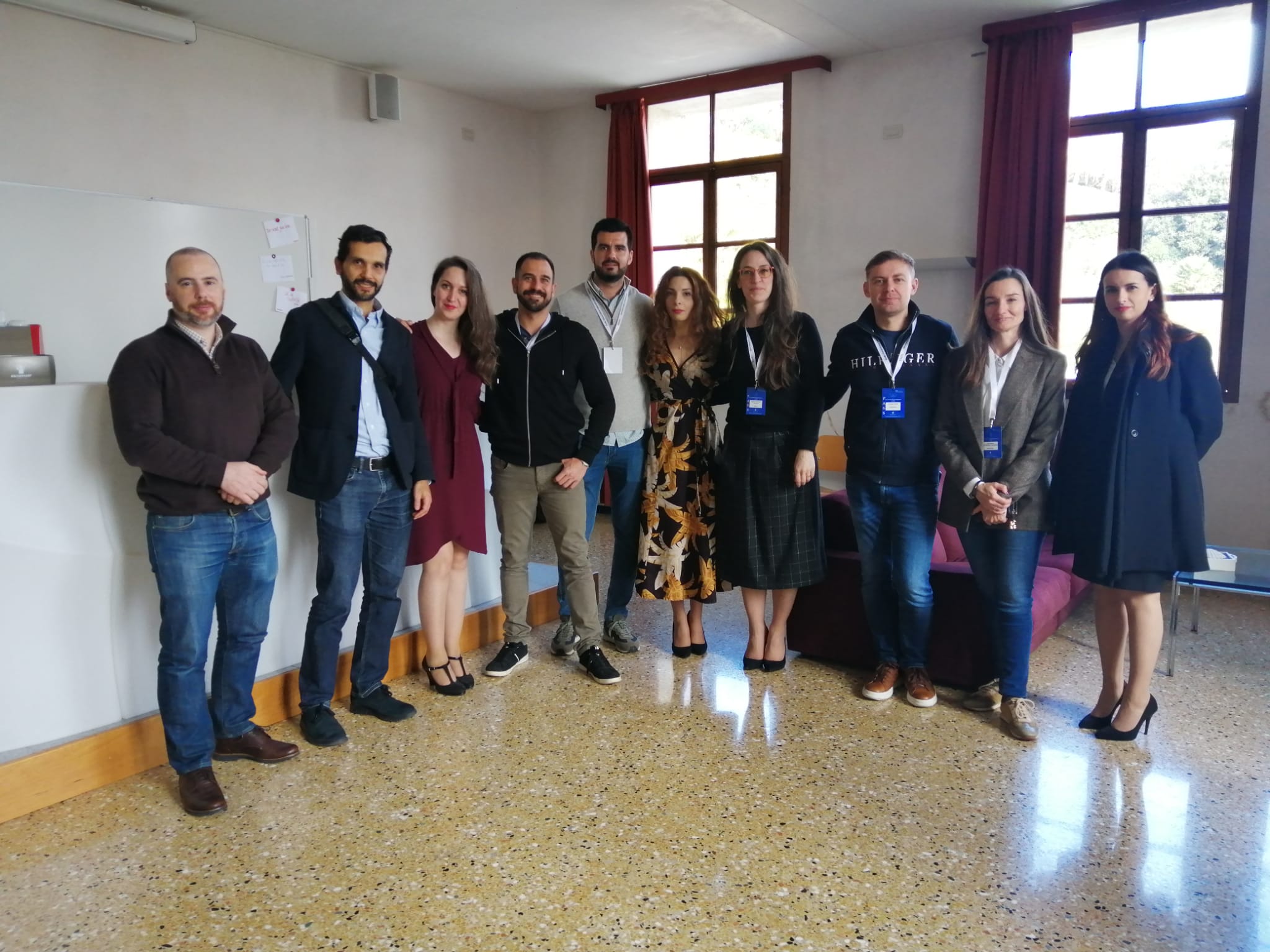 Dieci partecipanti in posa in un'aula, con i badge al collo.