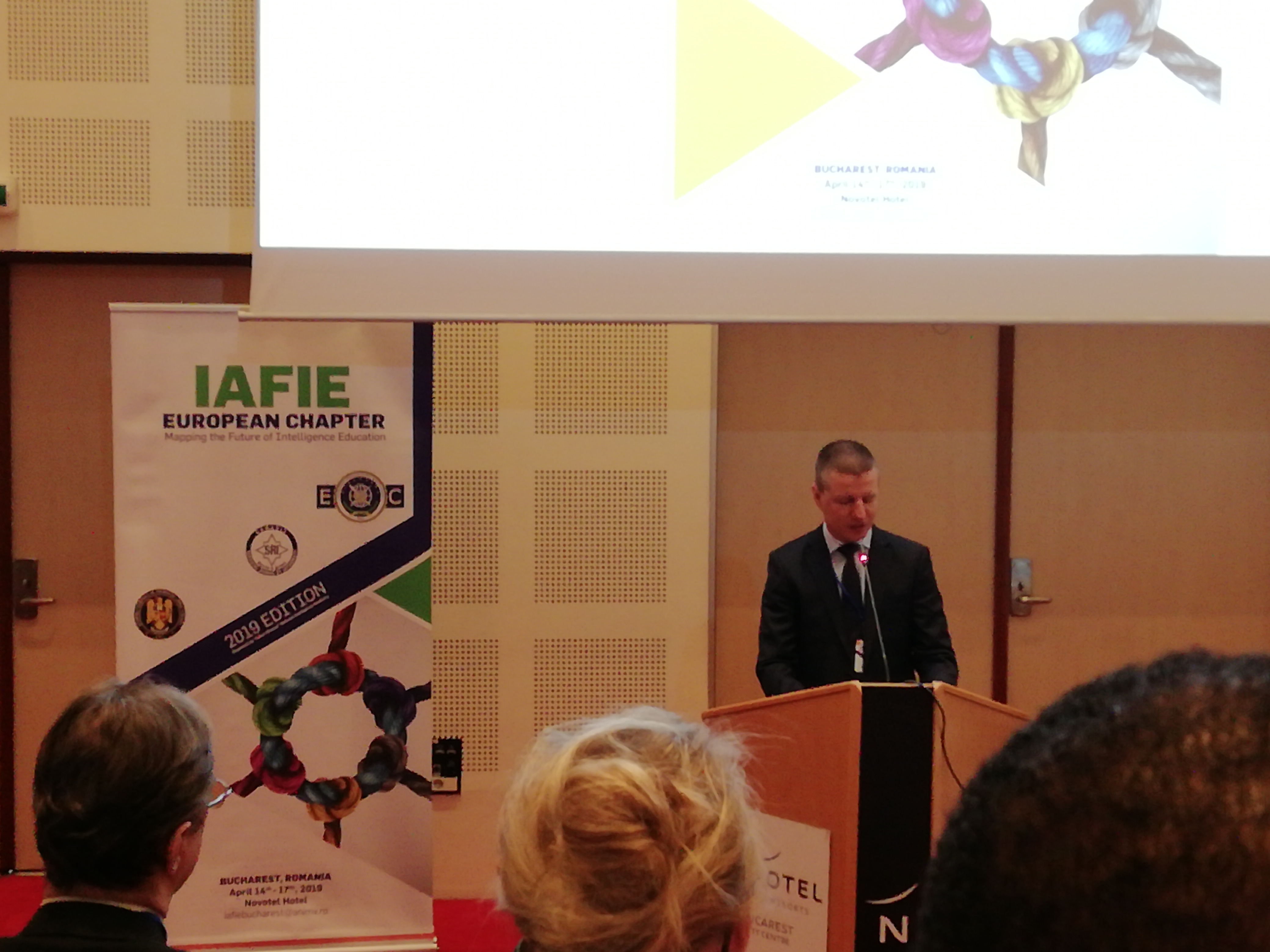 Un relatore al podio accanto al banner dello IAFIE European Chapter.