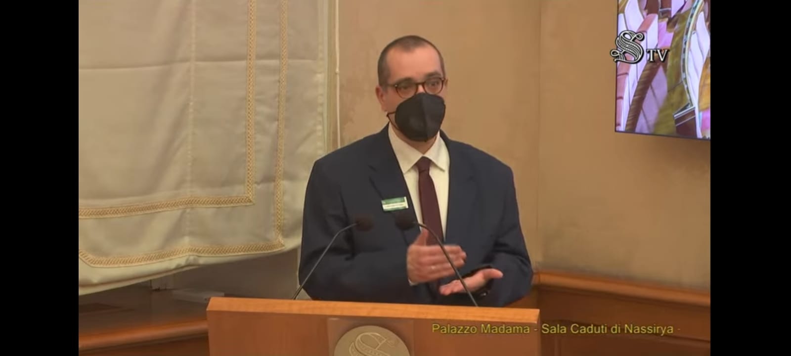 Un relatore con la mascherina parla dal banco della sala del Senato.